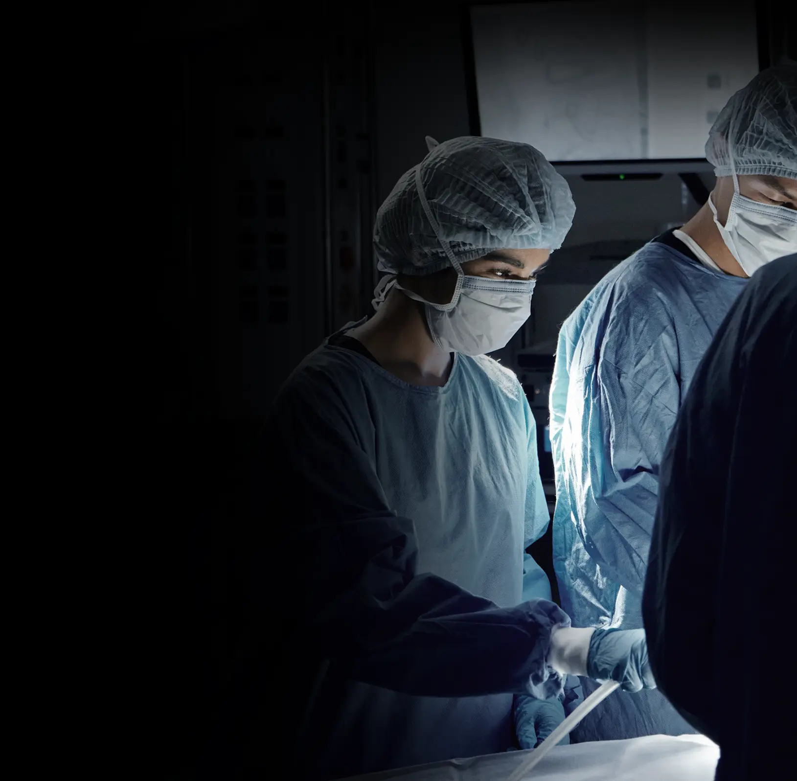 Surgical team operating in a darkened theatre