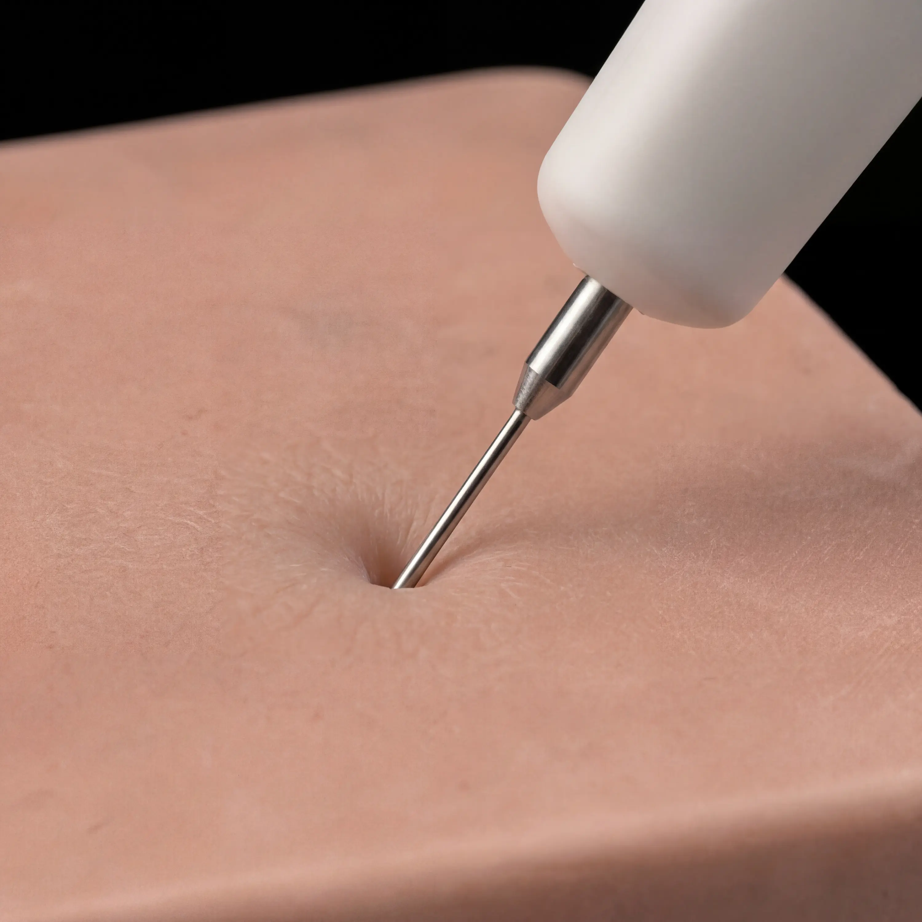 Close-up of the Winco USG needle handpiece entering the simulated tissue pad
